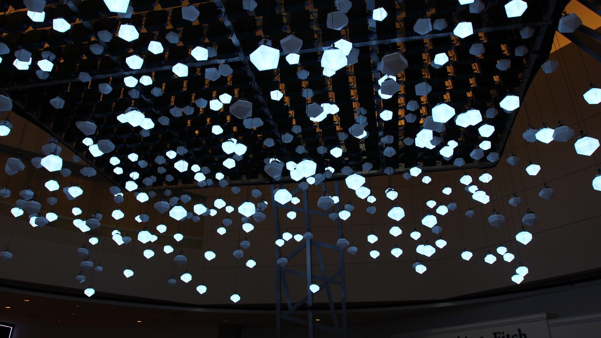 A lighting arrangement hangs from the ceiling of the Love Lights installation in 
                        Toronto, Ontario, Canada